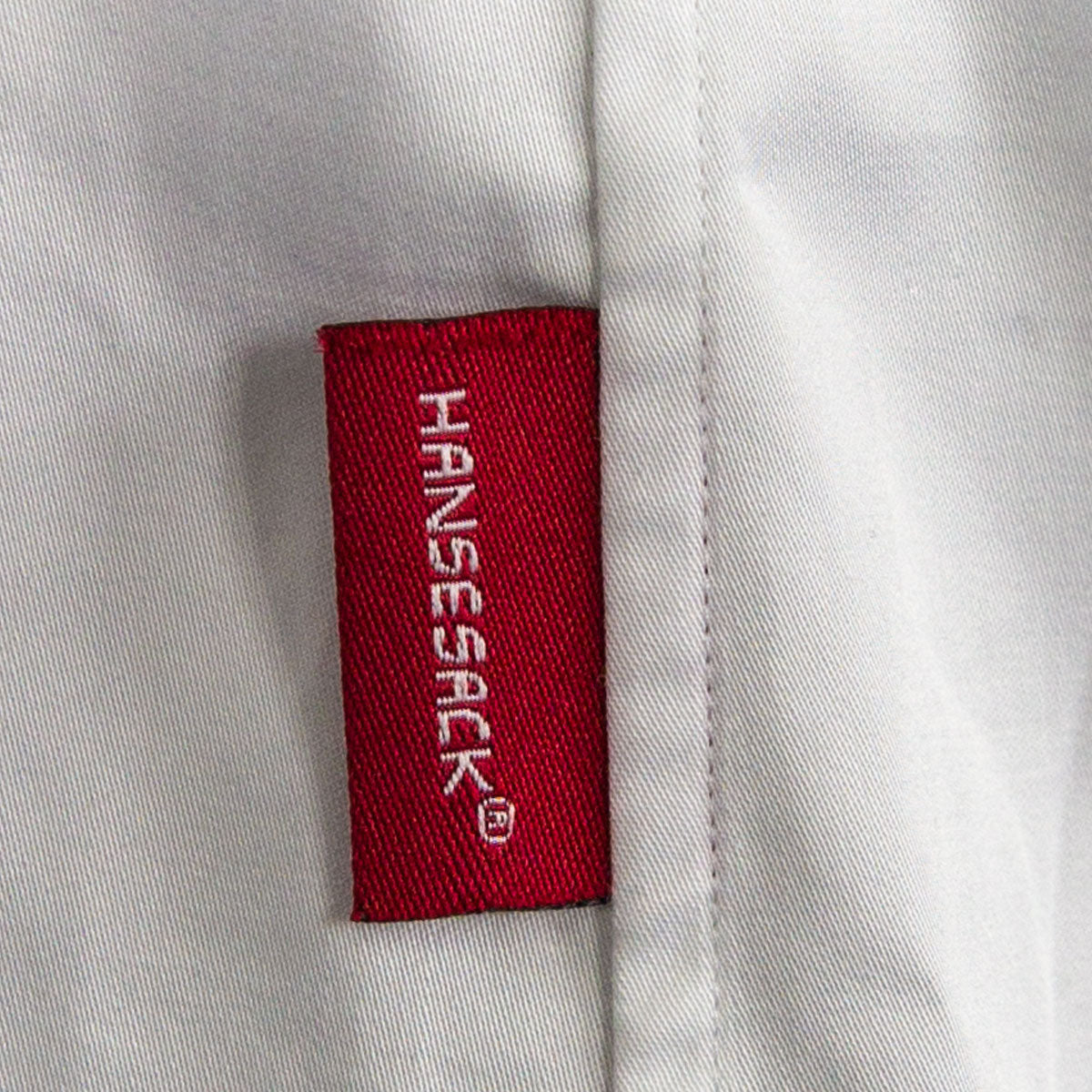 Hansesack Produktbild weißes Business-Hemd seidig glänzend Nahaufnahme von Hansesack Badge